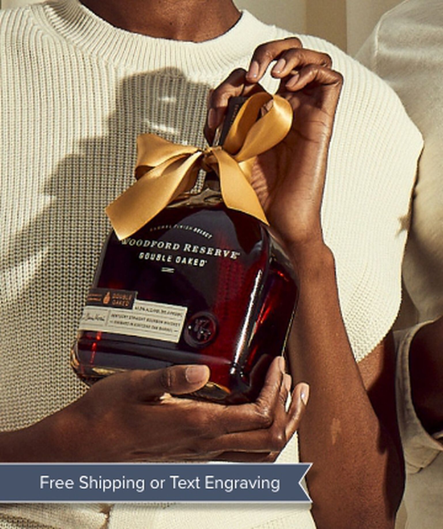 Two Woodford Reserve bottles with gold ribbons being held